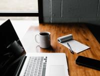 laptop, coffee mug, notebook, and smartphone