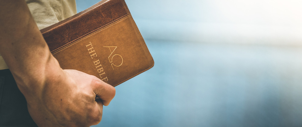 pastor carrying a Bible