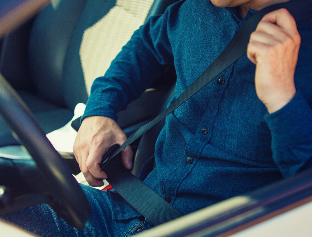 driver putting on seatbelt in the car