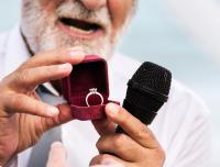 preacher with a microphone showing an engagement ring