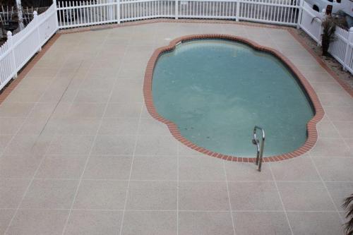 Decorative Concrete pool deck with tile pattern and brick border