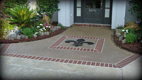 Decorative Concrete front porch with brick borders and a Fleur De Lis