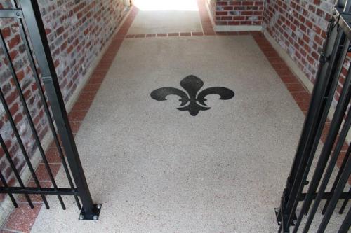 Decorative Concrete patio area with brick borders and a Fleur De Lis