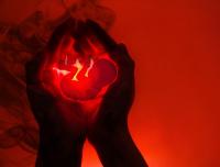 fetus being held in the hands on red background