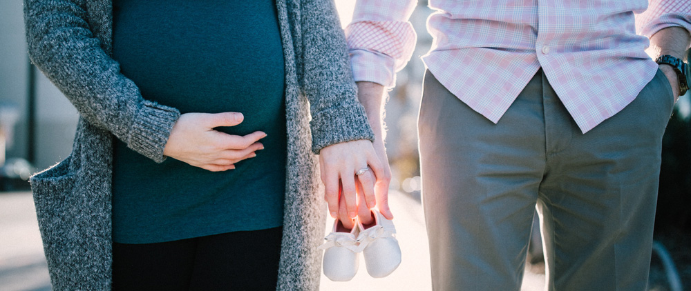couple holding baby shoes