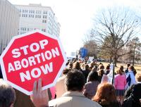 Stop abortion now sign held by pro-life demonstrator