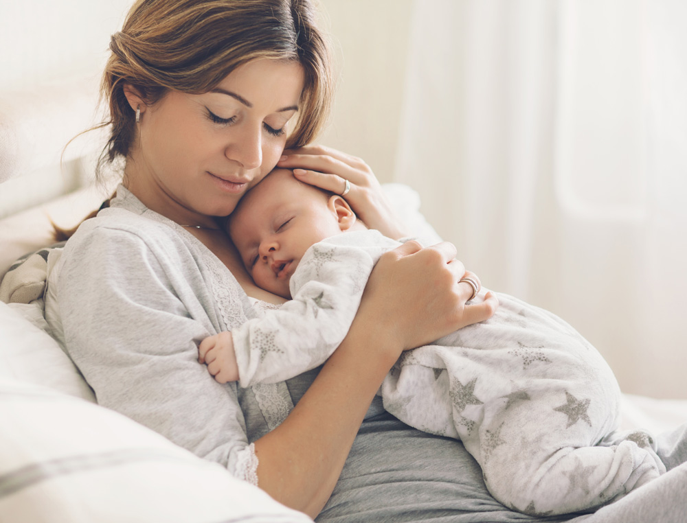 a mother tenderly holds her infant