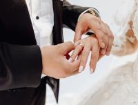 Groom puts wedding ring on bride's finger