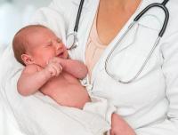 Crying baby held by pediatrician