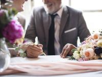 Adults sign a marriage license