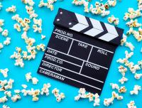 movie clapperboard on a blue background with popcorn