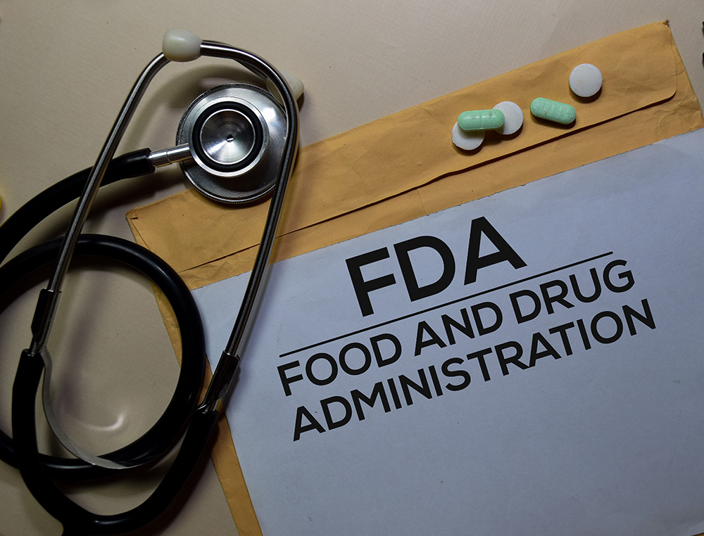 stethoscope, manilla envelope with the words FDA written on it and several loose pills