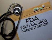 stethoscope, manilla envelope with the words FDA written on it and several loose pills