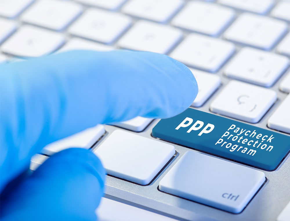 computer keyboard showing finger pressing the Paycheck Protection Program key