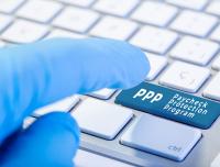 computer keyboard showing finger pressing the Paycheck Protection Program key