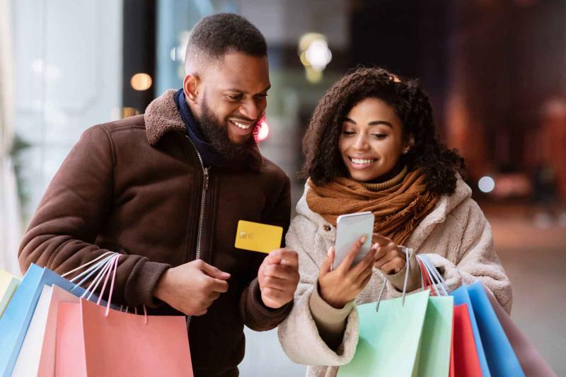 husband & wife looking at app on phone during shopping 