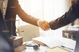 Two men shaking hands at a desk