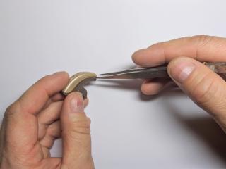 A hearing instrument specialist performs routine hearing aid maintenance at Elite Hearing. 