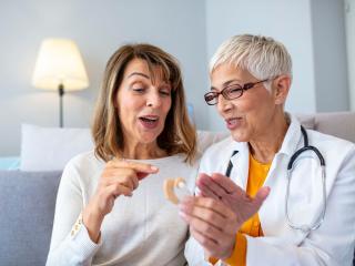 A Patient and an Audiologist Explaining Features of Earing Buds at Clinic in Florida