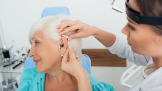 woman getting a hearing aid fitting