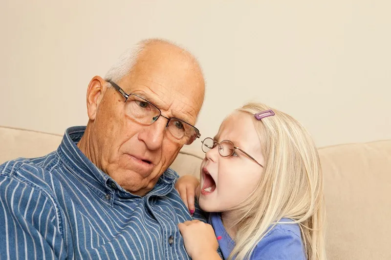 girl yelling to grandpa with hearing loss