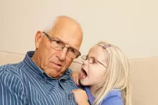 girl yelling to grandpa with hearing loss