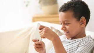 young boy wearing hearing aid