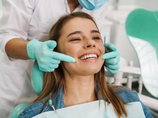 woman smiling with dentist pointing at her mouth | Restorative dentist in Baton Rouge 70809