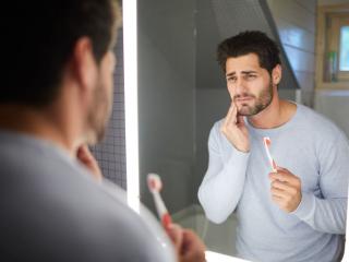 Man with mouth pain brushing teeth | emergency dentist in Baton Rouge 70809