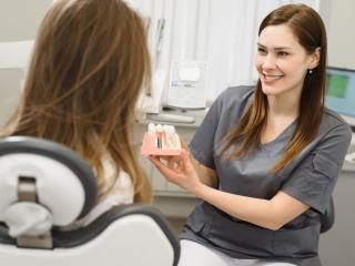 dentist showing dental implants to patient | restorative dentist in Baton Rouge 70809