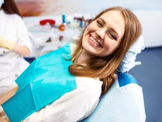 woman smiling in dentist chair after fixing tooth pain with a root canal | Baton Rouge 70809