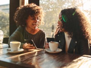 woman laughing at a cafe | get a perfect smile with teeth whitening in Baton Rouge 70809
