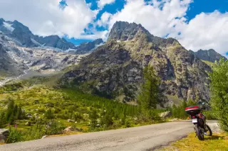 Motorcycle parked on the roadside, framed by a mountain backdrop.