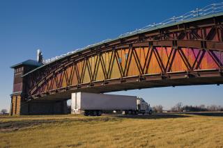 Truck driving beneath a bridge