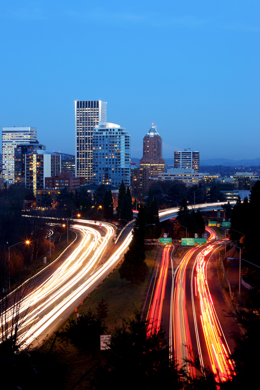  City skyline at night with moving traffic below