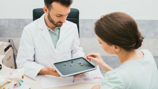 Doctor and Patient Inspecting Hearing Aid Machine at Elite Hearing Center in Florida