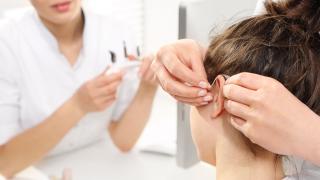 An Audiologist Fixing Hearing Aid Machine in Patient Ears in Florida