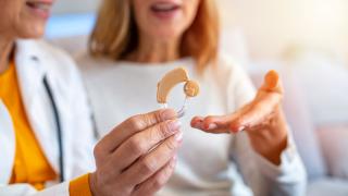 A Doctor Showcases a Hearing Aid Machine's Design and Functionality in Florida