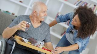 senior man getting help in his home from non-medical home care assistant