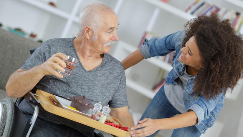 senior man getting help in his home from non-medical home care assistant