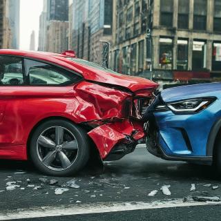 A blue car crashed into the back of a red car