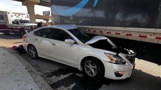 White car crashed under side of truck trailer