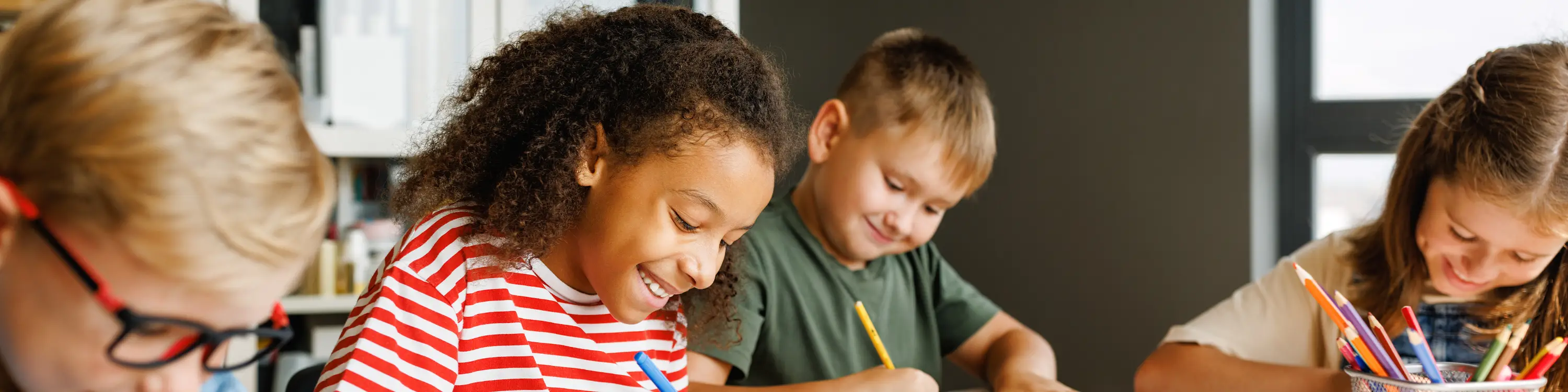 Students smiling and performing a writing assigment