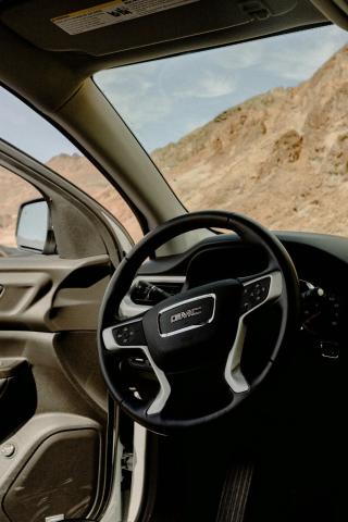  The steering wheel of a GM vehicle with desert mountains in the background - Remanufactured GM Transmission