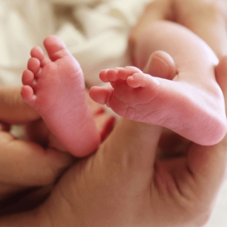 a mother holding her baby's feet - birth injury attorneys in dallas tx