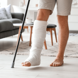 A man using a cane with a broken leg in a while cast - broken bone injury attorney in new mexico