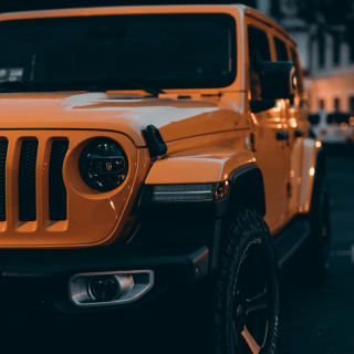 the front an orange jeep with a remanufactured jeep transmission from patriot engines