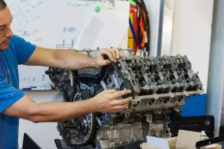 A KIA engine being remanufactured by a man at Patriot Engines