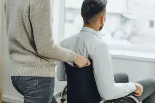 a woman caring for a man in a wheelchair who has a spinal cord injury - spinal cord injury attorney in new mexico
