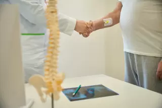two men shaking hands in the doctor's office after one had a spinal cord injury - spinal cord injury attorney in texas